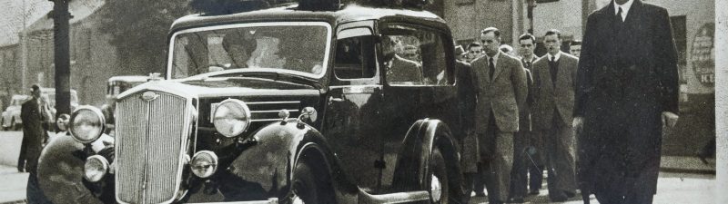 men following a funeral car